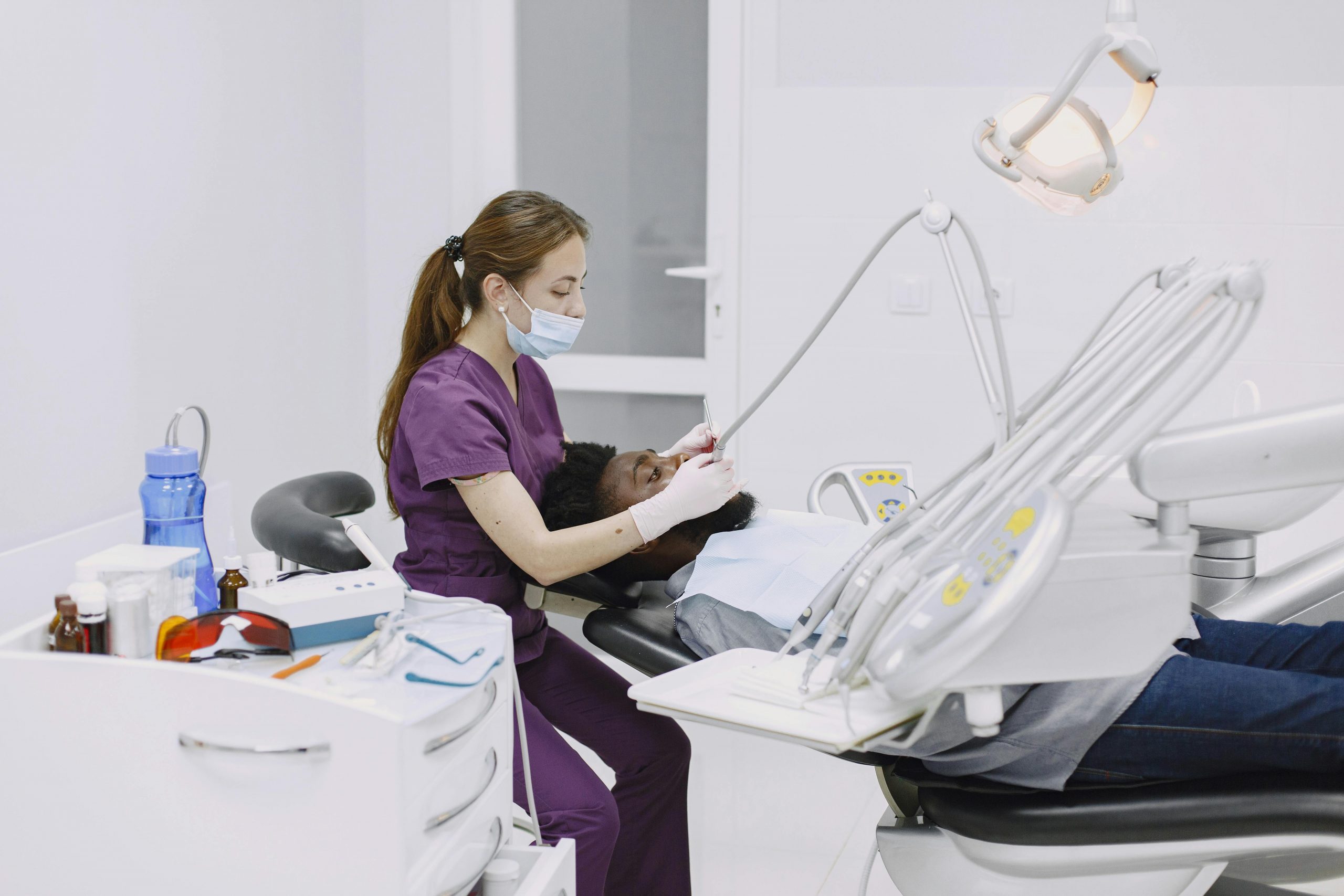 A professional dentist performs a checkup on a patient in a modern dental clinic.